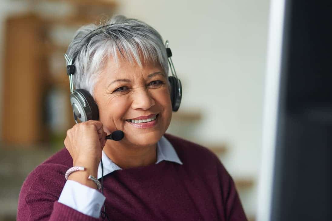Smiling female call center representative wearing a phone headset