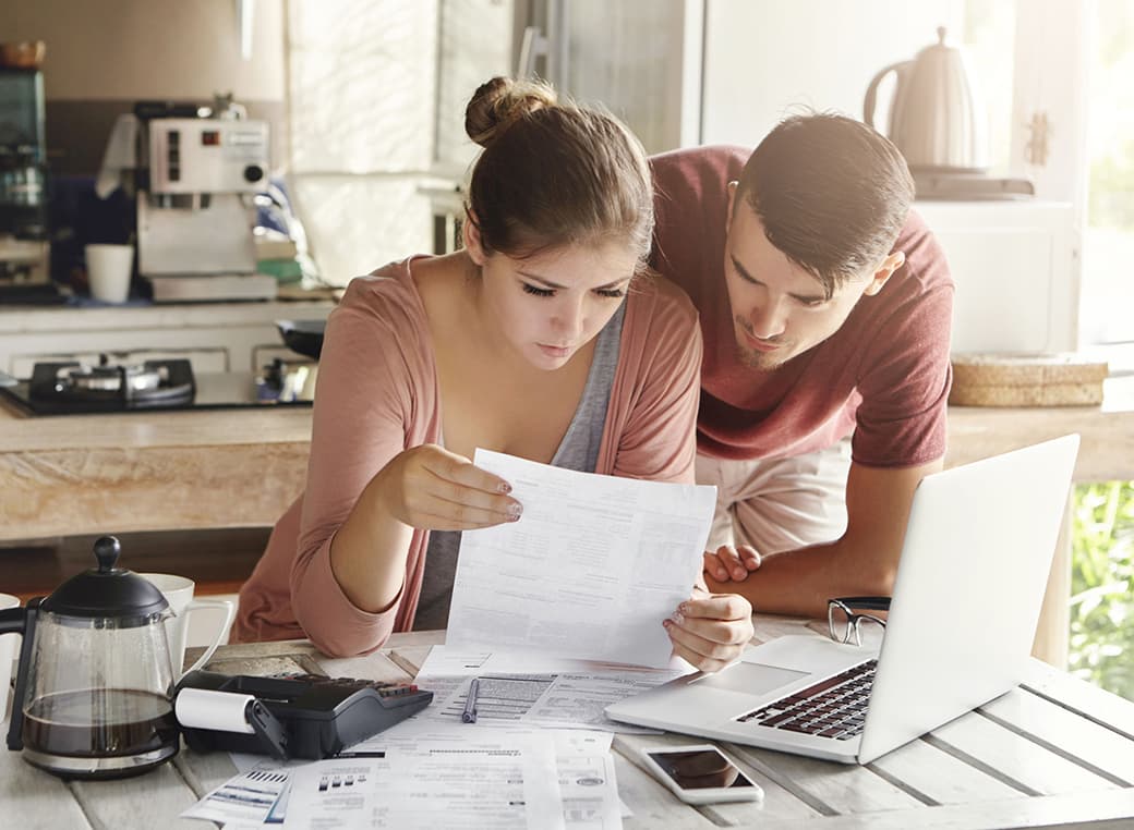 Wife studying bill together with her husband.