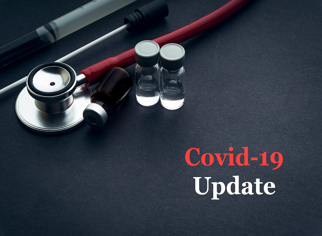 COVID-19 update with stethoscope, medical swab and vial on black background. 