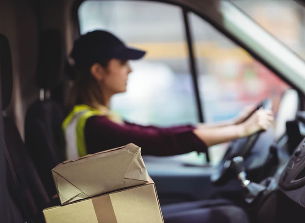 Delivery person with packages in vehicle.