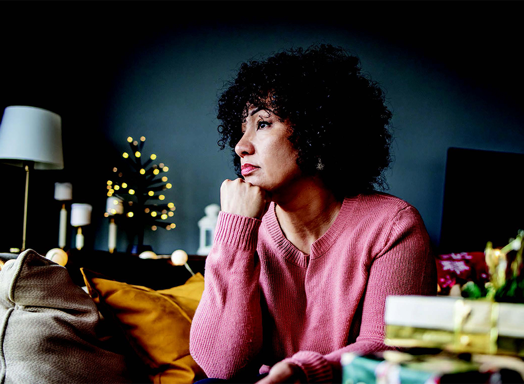 A mid-aged woman starring out the window not showing much emotion.