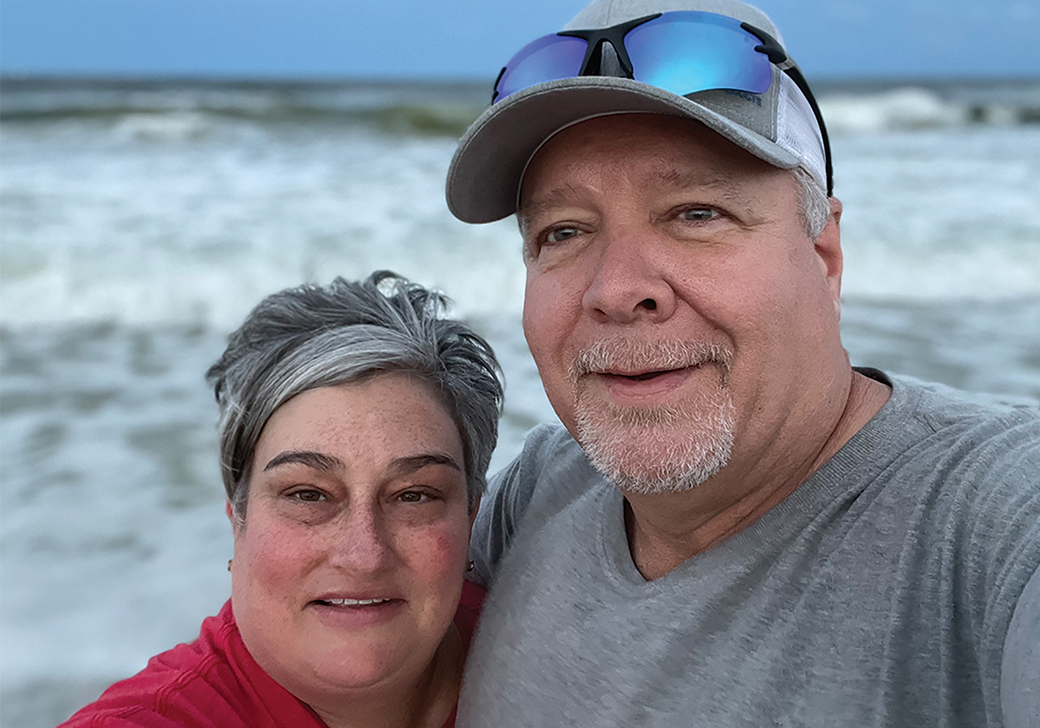 A woman and a man taking a selfie in front of the ocean.