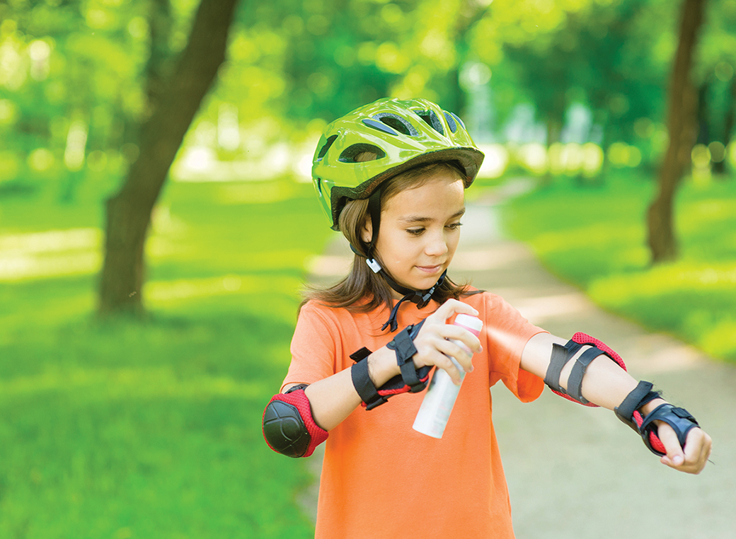 A young girl roller blading putting sunscreen on.