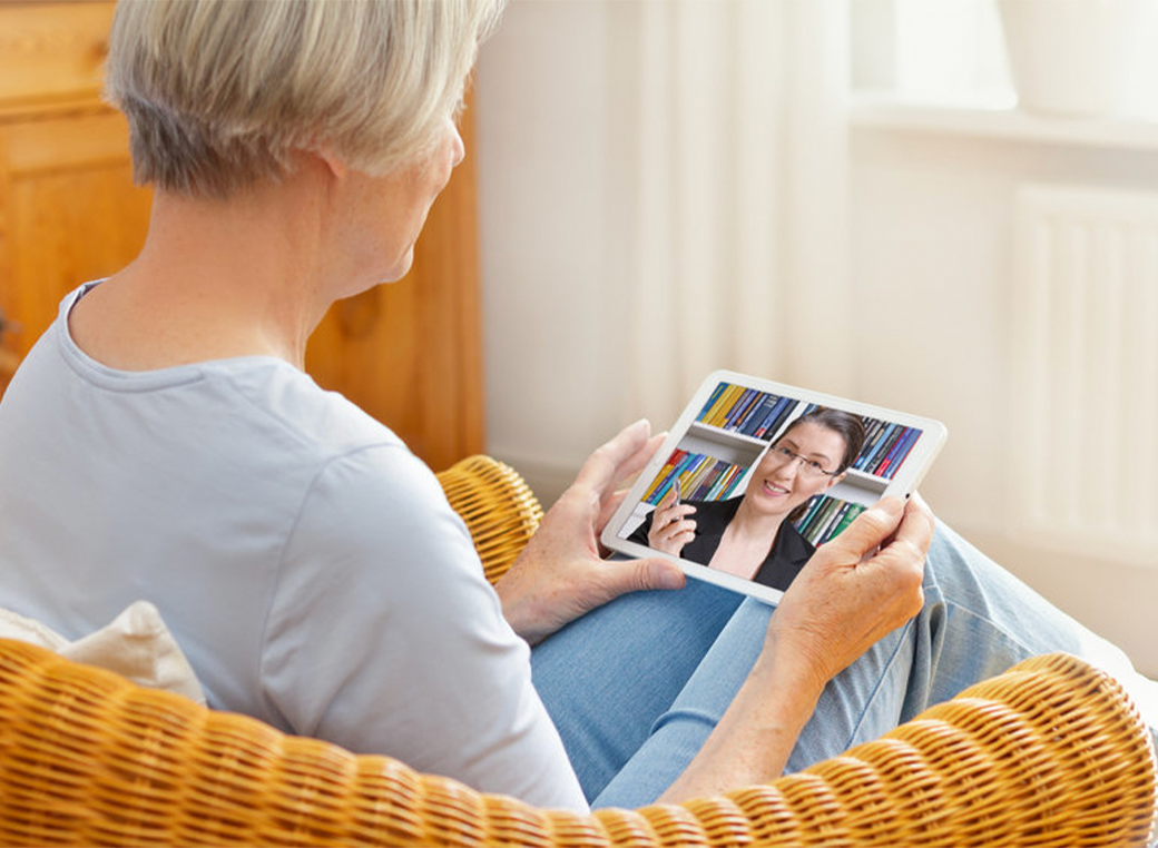 Teletherapy senior woman using a tablet to speak to a counselor.