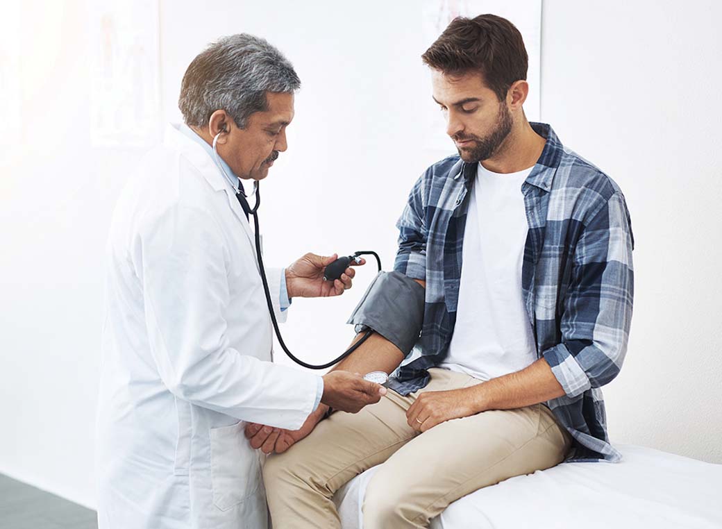 A physician checking a patient's blood pressure during an office visit.